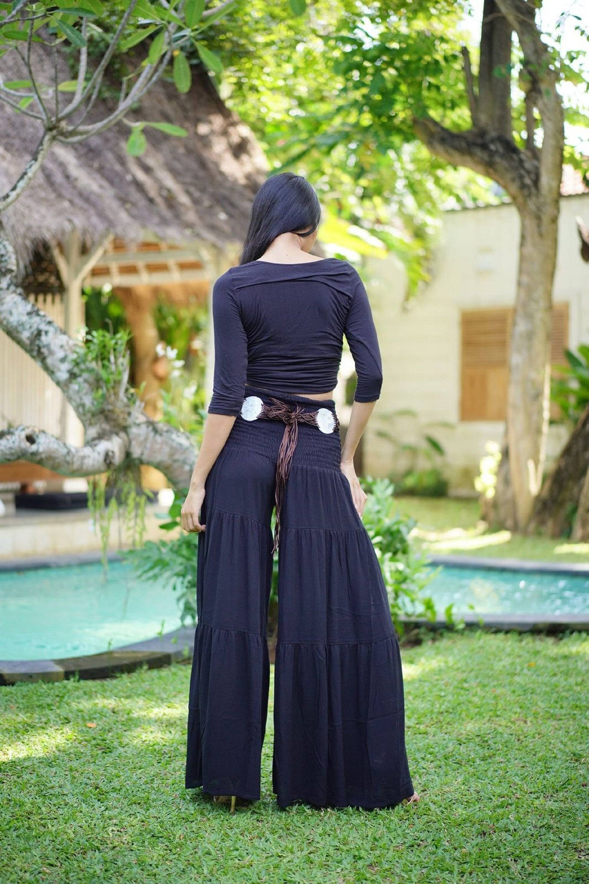 Back view of black ruffled palazzo pants with a smocked waist, showcasing a comfortable and stylish fit for all sizes.