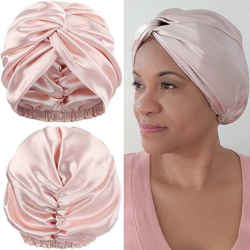Silk Bonnet Amara De Luxe in soft pink, showcasing a twisted front and elastic back. Made from 100% Mulberry Silk for hair care.
