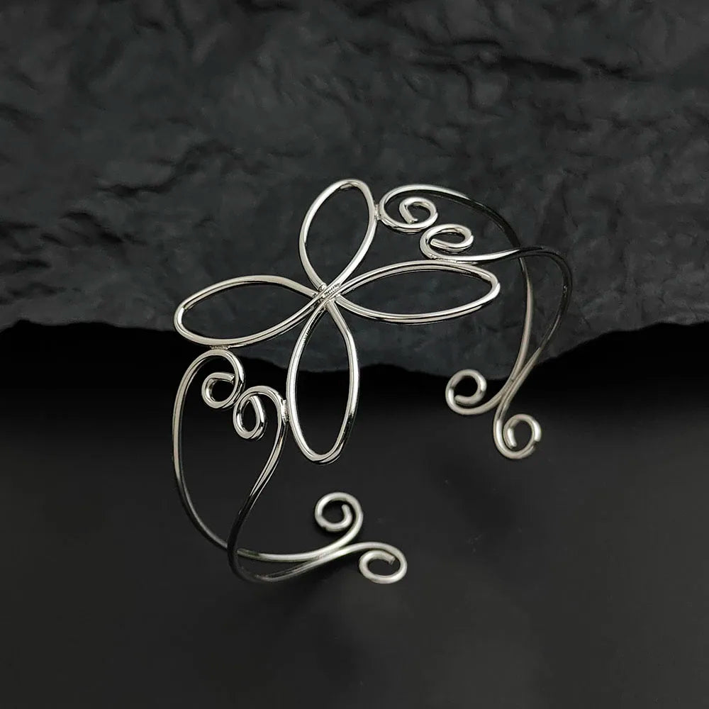 The silver bloom hair cuff standing on a black table