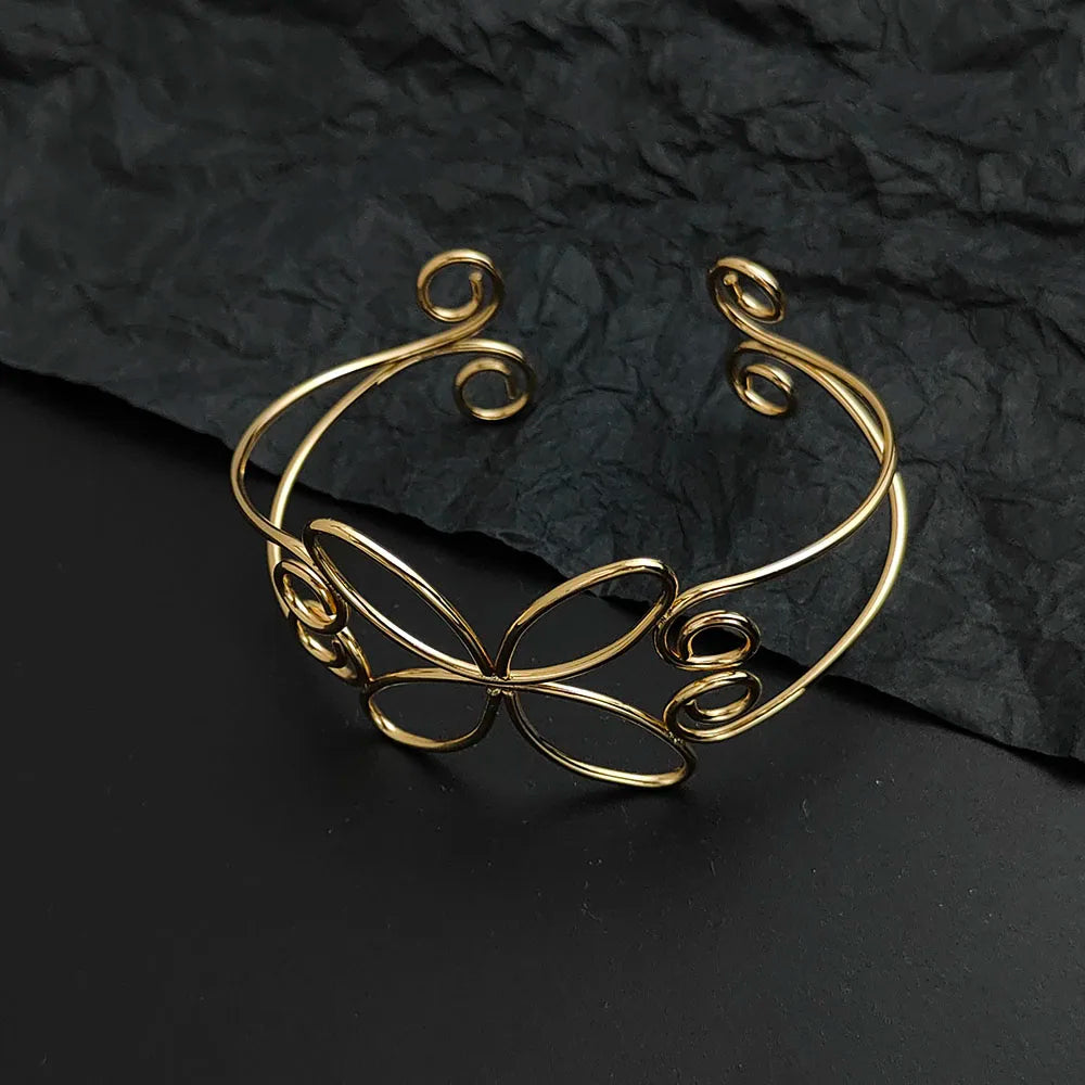 the gold bloom hair cuff laying on a black table