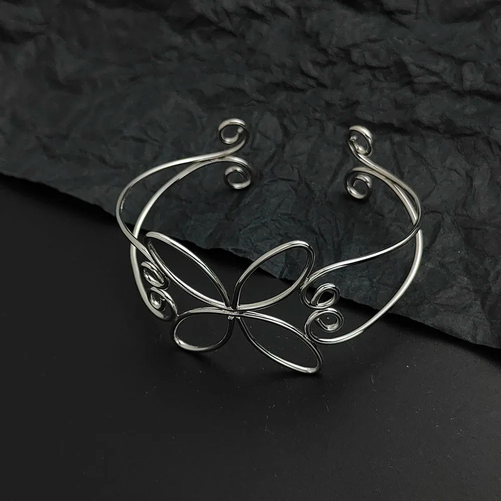 the silver bloom hair cuff laying on a black background