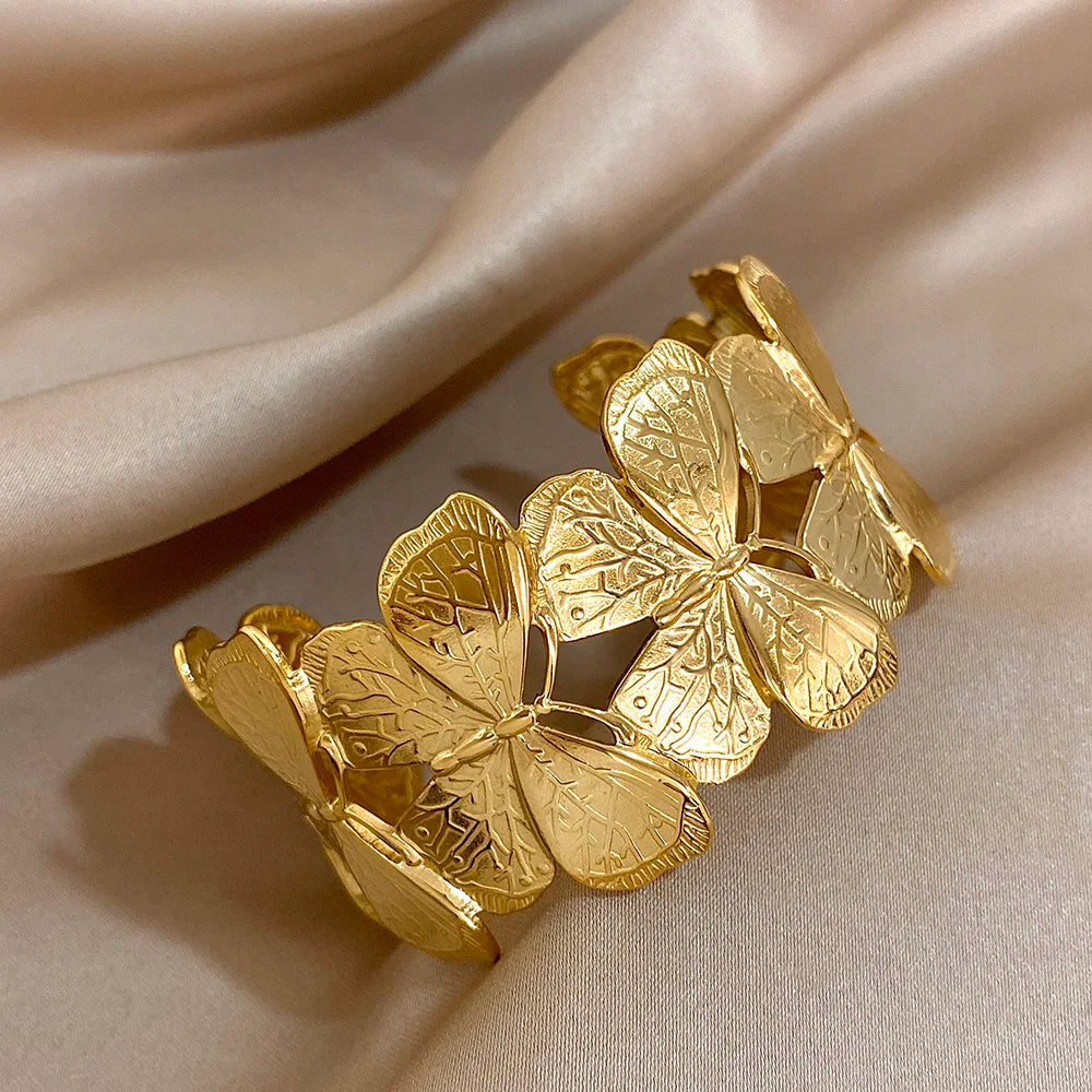 Gold butterfly hair cuff viewed at an angle, highlighting the engraved wing details.