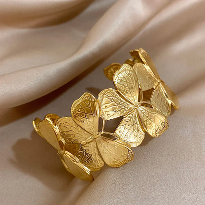 Gold butterfly hair cuff viewed at an angle, highlighting the engraved wing details.