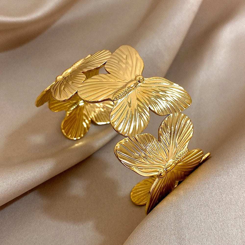 Gold butterfly hair cuff featuring detailed butterfly wing patterns on soft satin fabric.