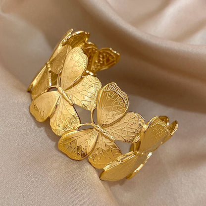 Gold butterfly hair cuff with delicate leaf-textured wings, displayed in close detail.