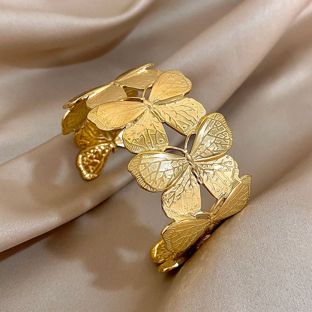 Gold butterfly hair cuff featuring delicate engraved wings, displayed on soft satin.