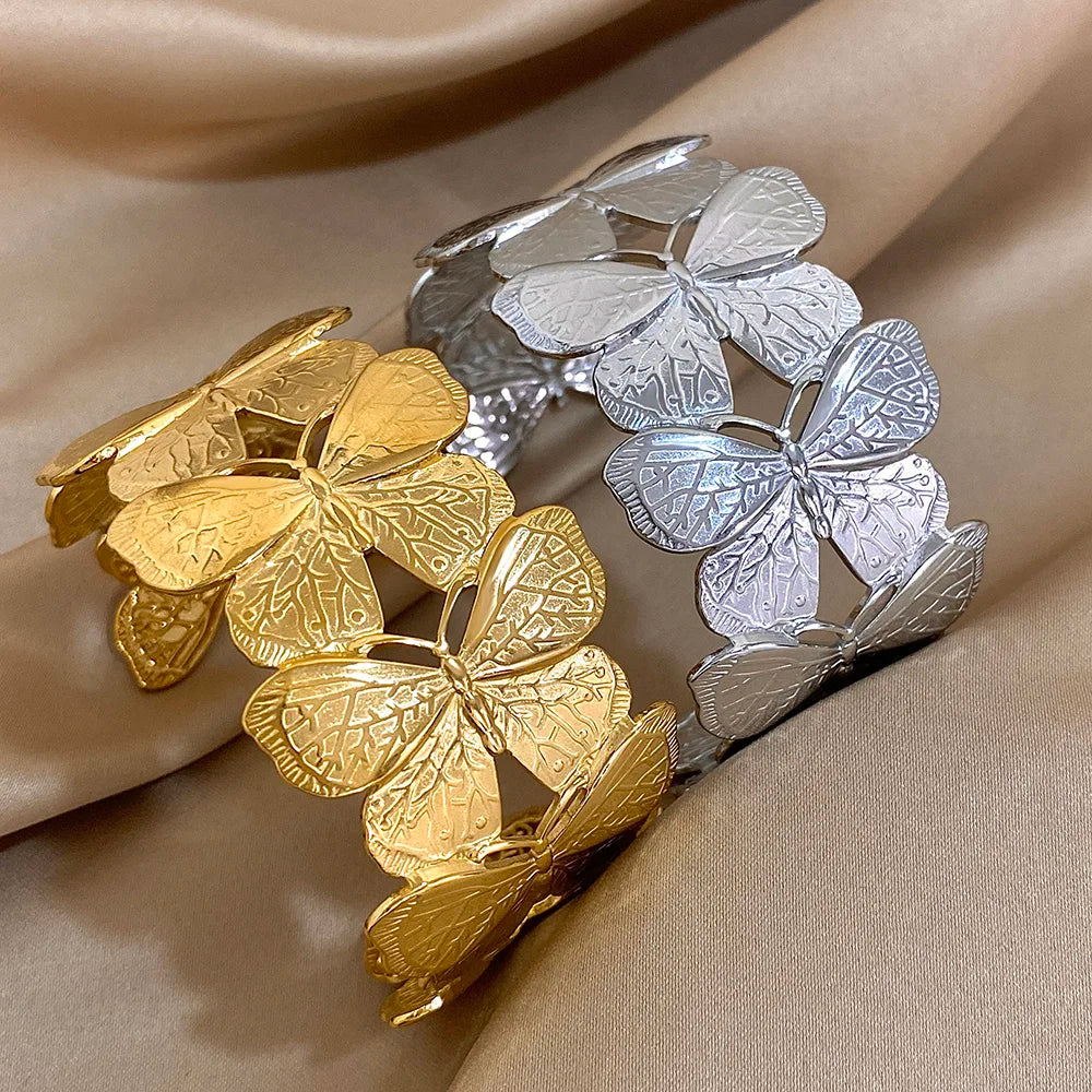 Butterfly hair cuff shown in gold and silver versions side by side on fabric background.