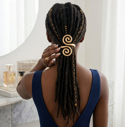 Matte gold spiral hair cuff holding locs in a low ponytail on a Black female model.