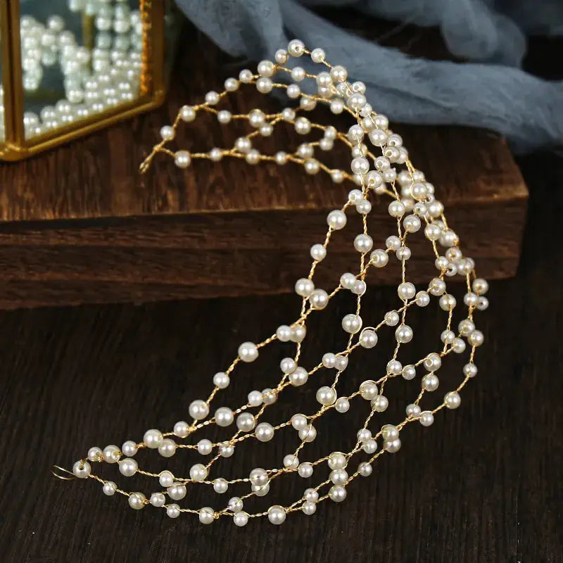 Elegant pearl headband with gold wire detailing, featuring multiple rows of pearls in a netted design. Perfect for bridal or formal occasions.