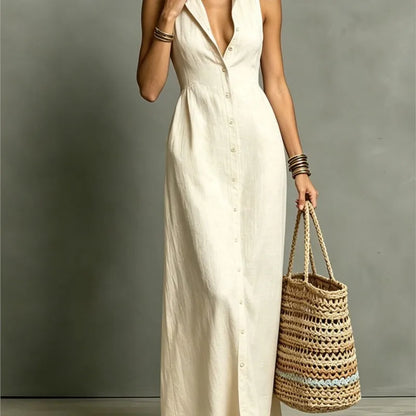 Woman in a white dress holding a woven bag against a gray background
