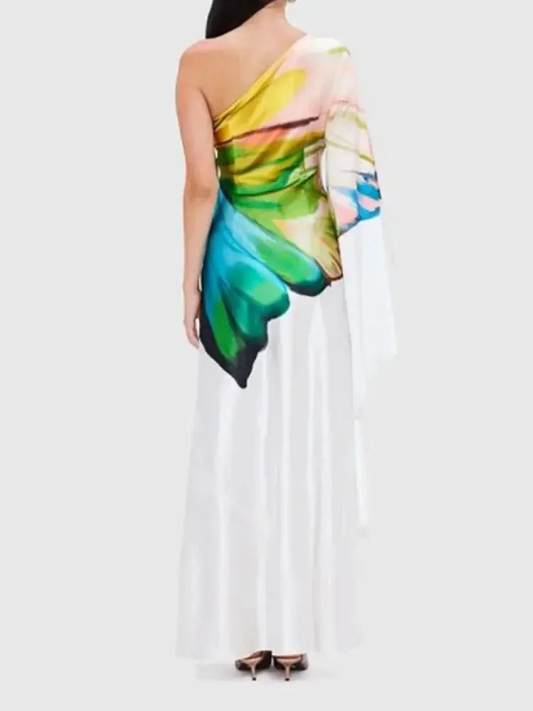 Back view of a one-shoulder maxi dress with a striking butterfly wing print. The flowing silhouette adds elegance to any occasion.