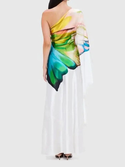 Back view of a one-shoulder maxi dress with a striking butterfly wing print. The flowing silhouette adds elegance to any occasion.