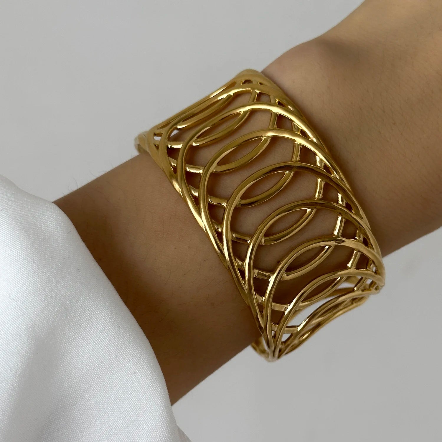 Gold cuff bracelet with open lattice geometric pattern, adding a bold and elegant touch to the wrist