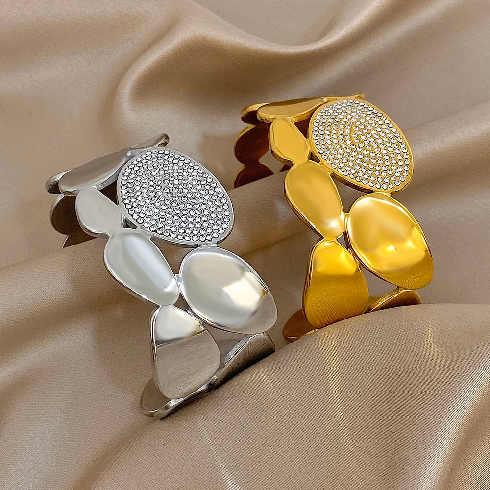 The Gold &amp; Silver Gold Crystal Geometric Wide Cuff Bracelet beside one another 