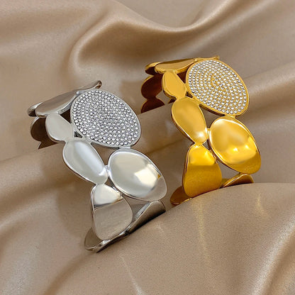 The Gold &amp; Silver Gold Crystal Geometric Wide Cuff Bracelet beside one another 