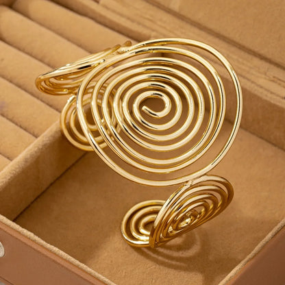 Gold swirl hair cuff with shiny gold finish, placed inside a jewelry box for display.