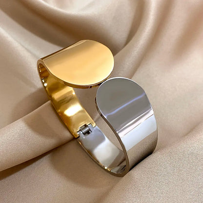 The Half Gold &amp; Half Silver Geometric Glossy Chunky Cuff Bracelet  on an brown background 