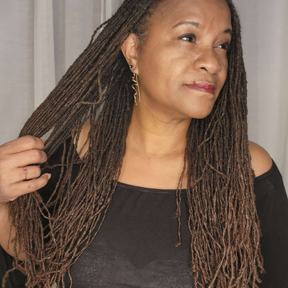 Woman with long, well-maintained locs after using the Loc Lint Remover. Helps remove lint and debris for cleaner, healthier hair.