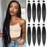 Woman with braided hair next to bundles of black hair extensions.