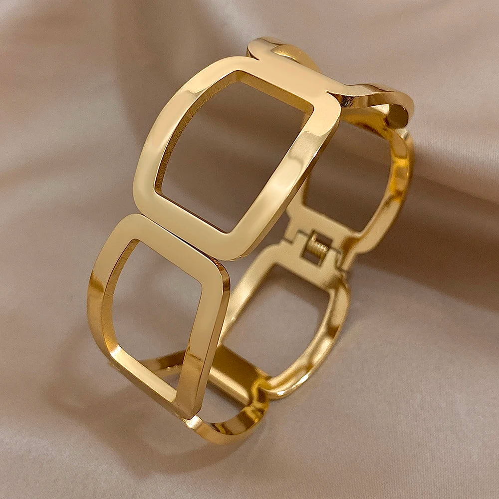 Side view of a gold link cuff showing the hinge and spring closure and smooth rounded frames