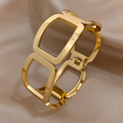 Side view of a gold link cuff showing the hinge and spring closure and smooth rounded frames