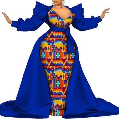 Royal blue satin overlay gown with a colorful geometric kente-style print panel, puff sleeves and a long train, on a white background.