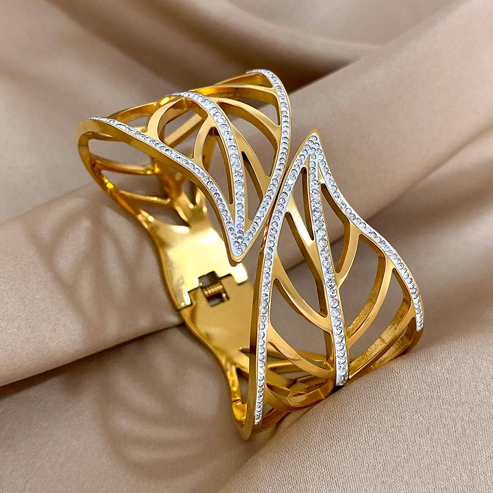 Gold crystal-edged leaf cuff with a visible hinge, on beige satin