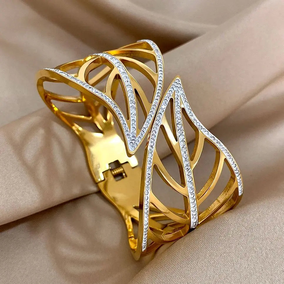 Gold leaf crystal cuff with a hinge and spring closure, on beige satin