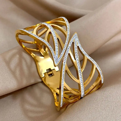 Gold leaf crystal cuff with a hinge and spring closure, on beige satin