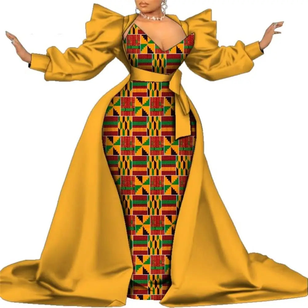 Mustard-yellow satin overlay gown with a geometric kente-style print panel and puff sleeves, on a white background.