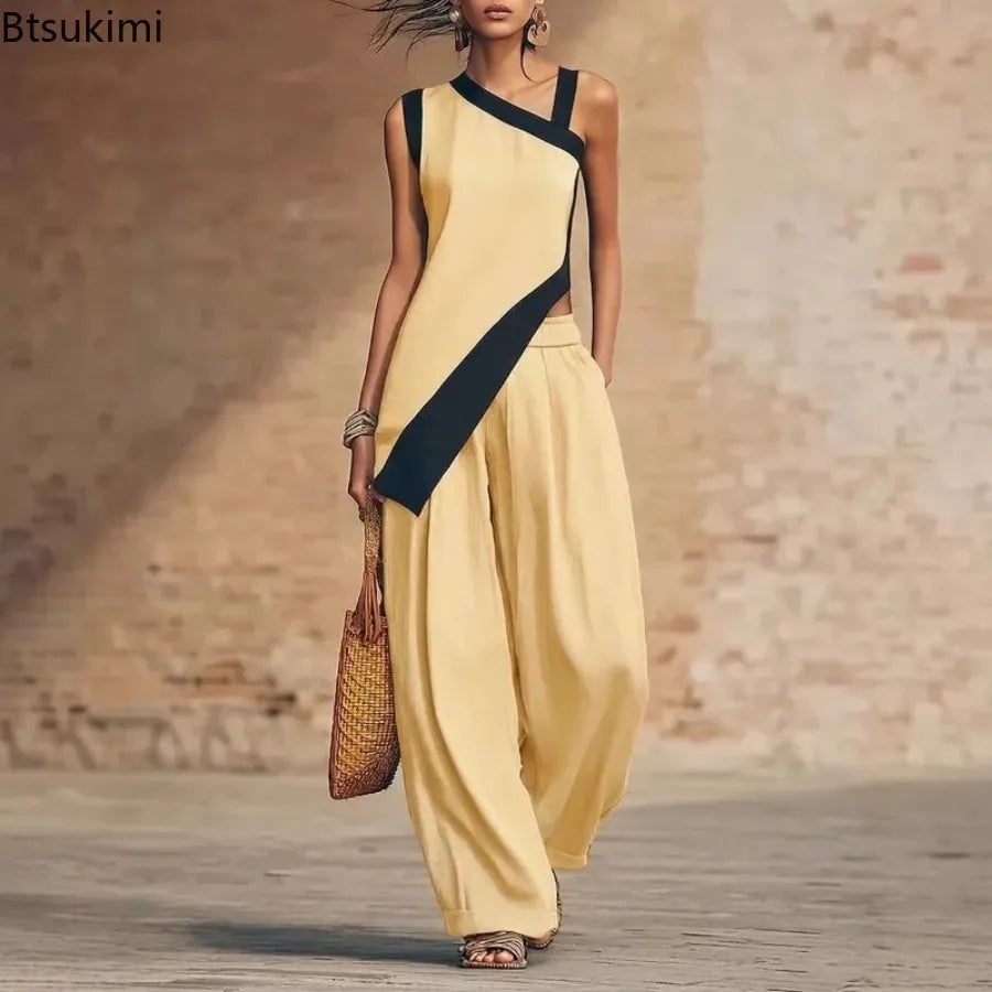 Woman wearing a yellow and black outfit with wide-leg pants, standing against a textured wall.