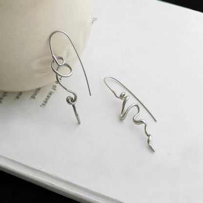 Silver earrings on a white surface