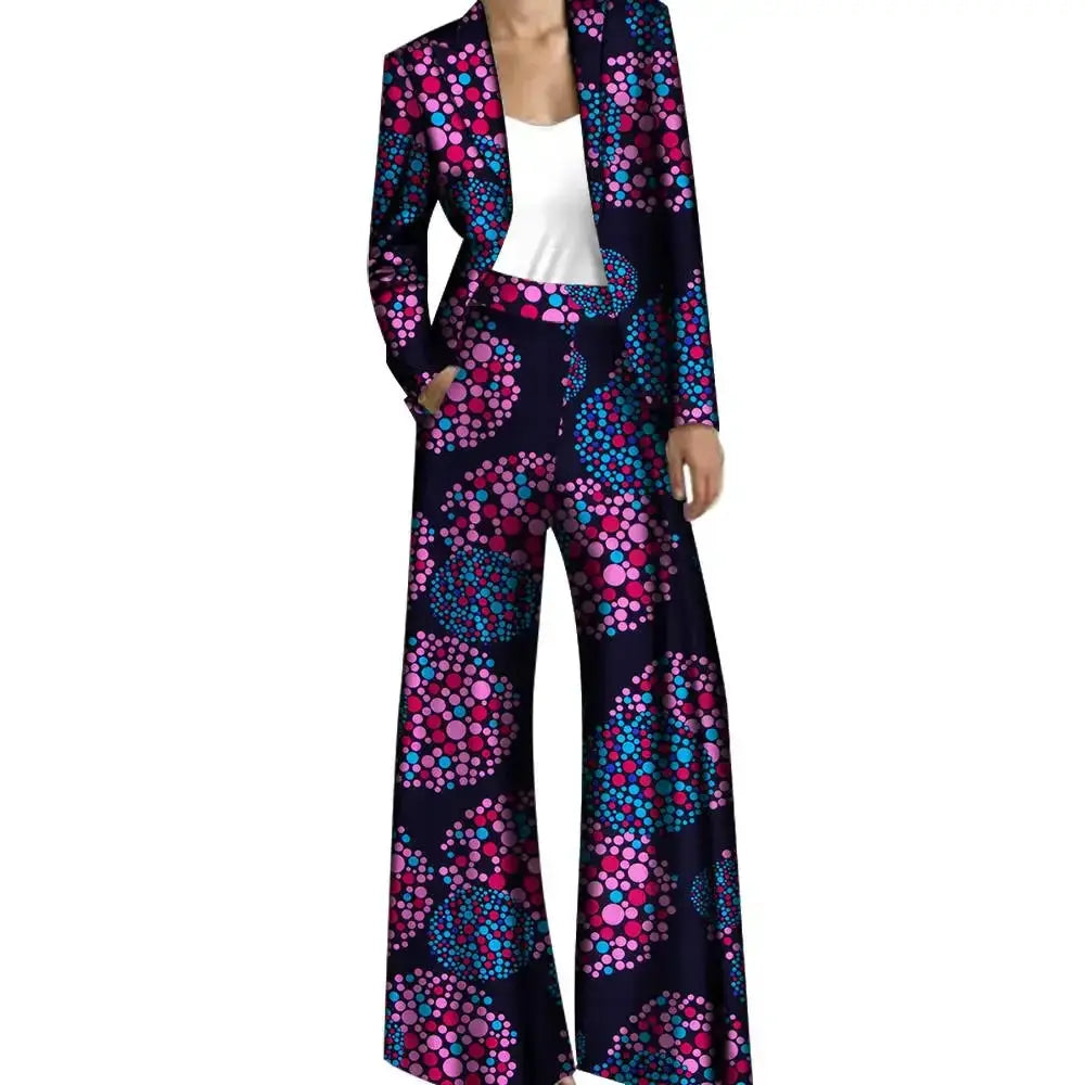 Dark blue African pantsuit with pink and blue circular patterns, including a fitted jacket and wide-leg trousers. A trendy and elegant outfit.