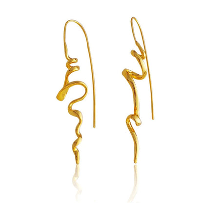 A pair of gold abstract wavy drop earrings with long fishhook wires, displayed on a clean white background with a subtle reflection.