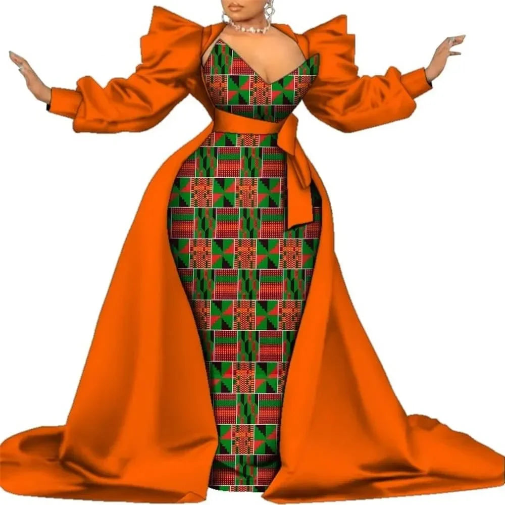 Orange satin overlay gown with a red and green circle-print panel, puff sleeves and a bow waist, on a white background.