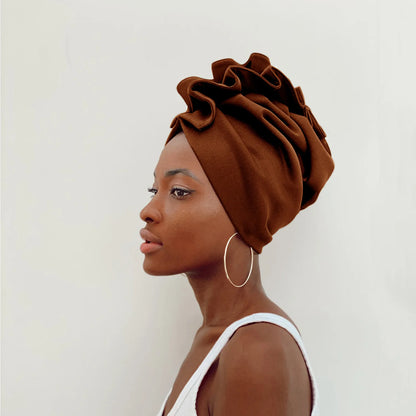 Woman wearing a brown headscarf with ruffles on a white background