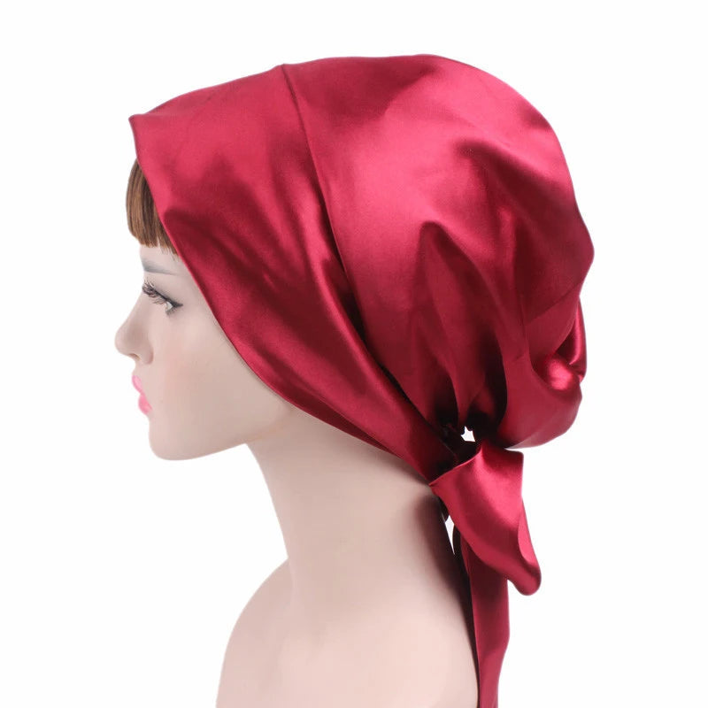 Red satin headscarf on a mannequin head against a white background
