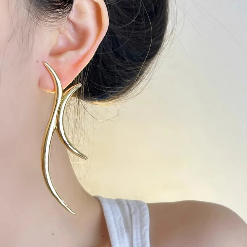 Modern gold sculptural earrings, side profile view