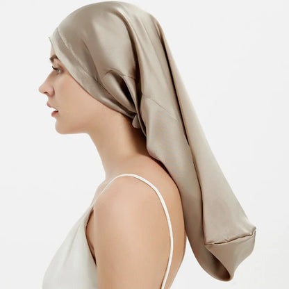 Woman wearing a beige satin hair towel on a white background