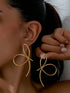 Gold hoop earrings worn by a person with a neutral background