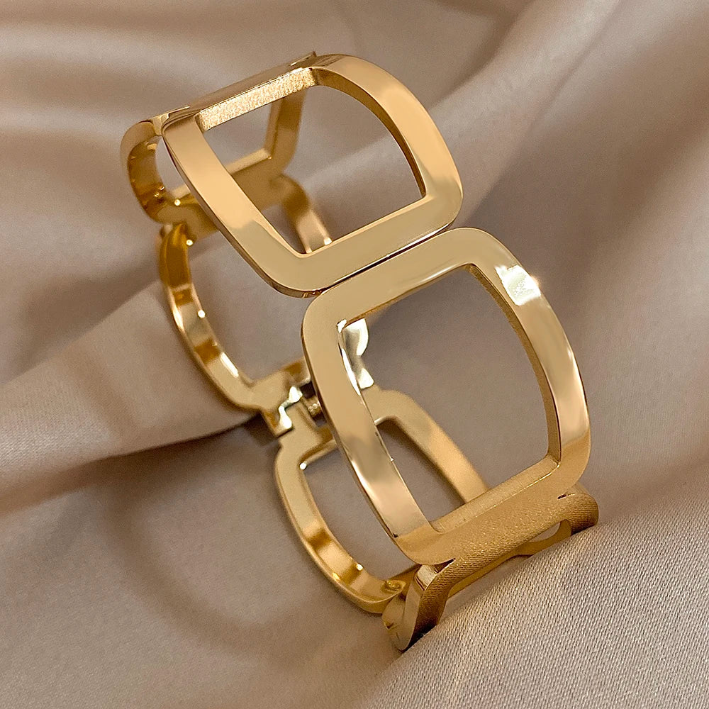 Gold geometric link cuff with smooth open frames, on beige satin fabric