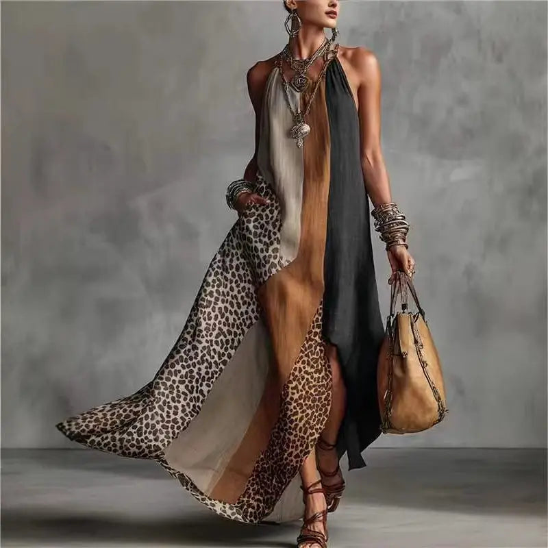 Woman wearing a long, flowing dress with leopard print and holding a brown leather bag against a gray background.