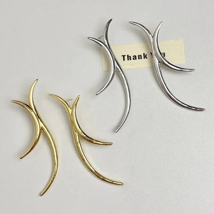 Sculptural gold and Silver antler-inspired earrings close-up