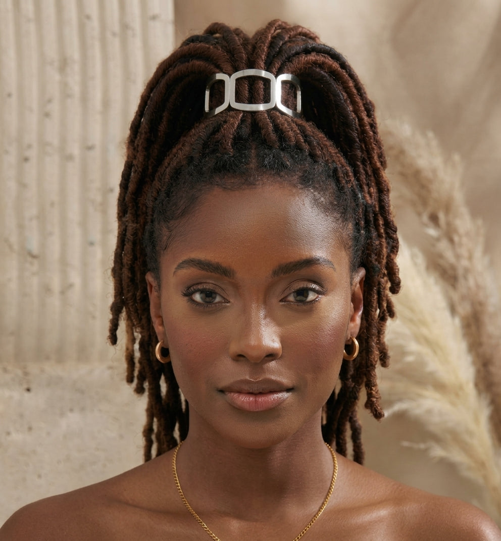 Front view of a woman with locs in a high ponytail, secured by a silver open-frame link hair cuff