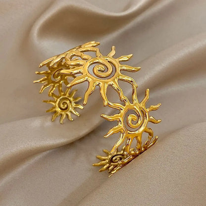 The Gold Spiral Hair Cuff and bracelet on an satin brown background