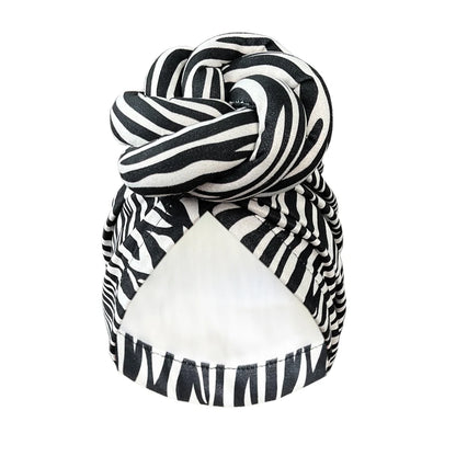 Black and white zebra-striped patterned knot turban headwrap with a stylish twisted knot. A bold and fashionable headwear choice for any outfit.