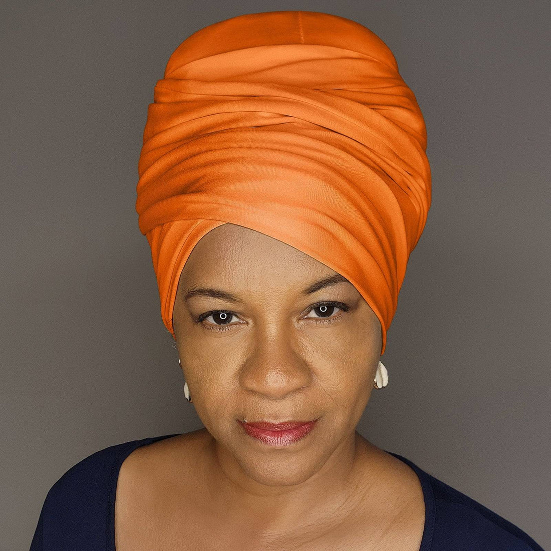 Elegant orange headwrap styled in a turban design. A versatile and fashionable accessory for a bold and sophisticated look.