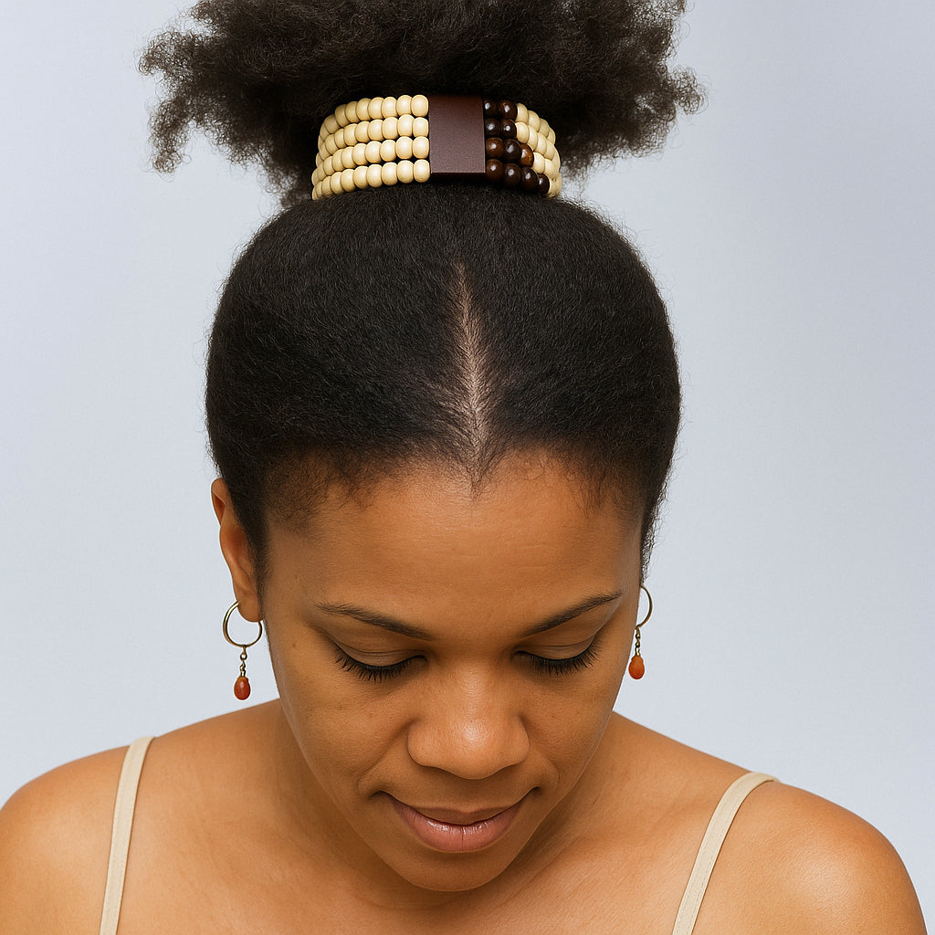 Woman with a styled hair bun wearing a decorative headband against a light blue background