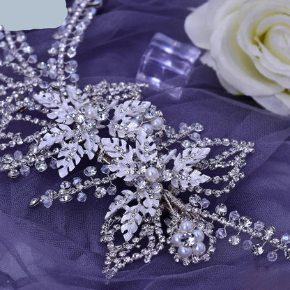 Close-up of silver bridal hairpiece with pearl flowers and crystal leaf detailing
