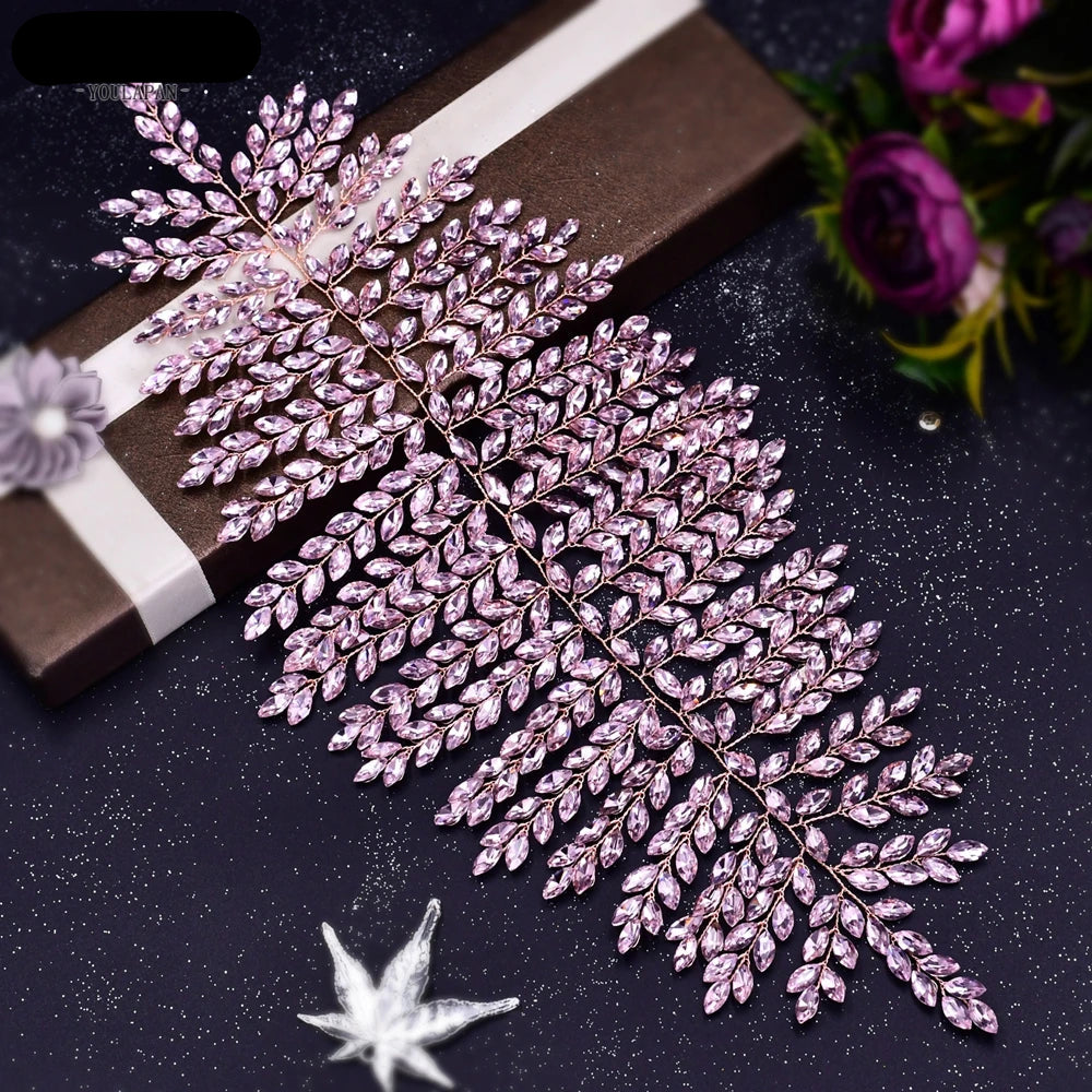 Pink leaf bridal crown displayed on a gift box with sparkling background.